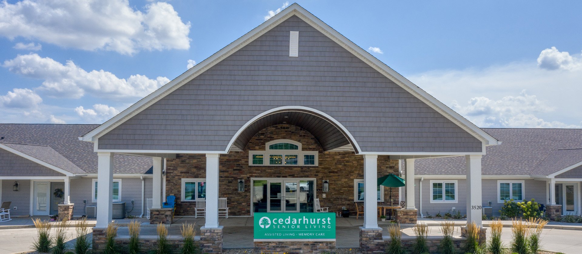 An inviting view of the Cedarhurst of Springfield, IL senior living community from the outside, complete with the main building and its distinctive sign
