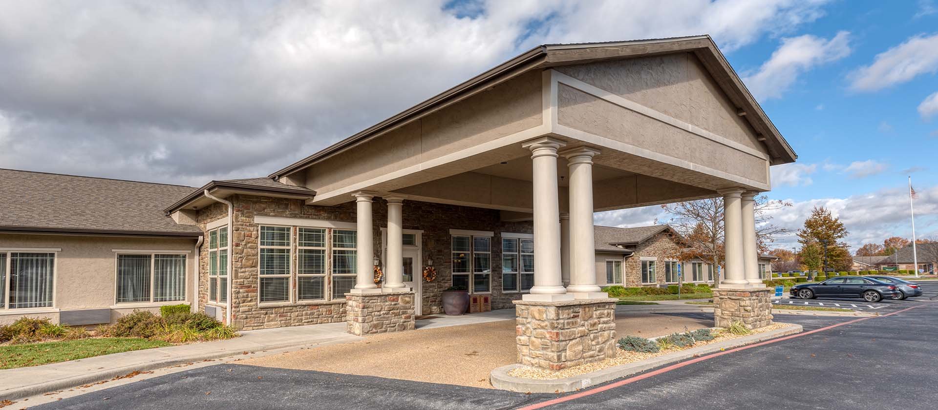 An inviting view of the Cedarhurst of Springfield, MO senior living community from the outside, complete with the main building and its distinctive sign