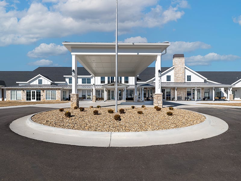 An inviting view of the Cedarhurst of Topeka senior living community from the outside, complete with the main building and its distinctive sign