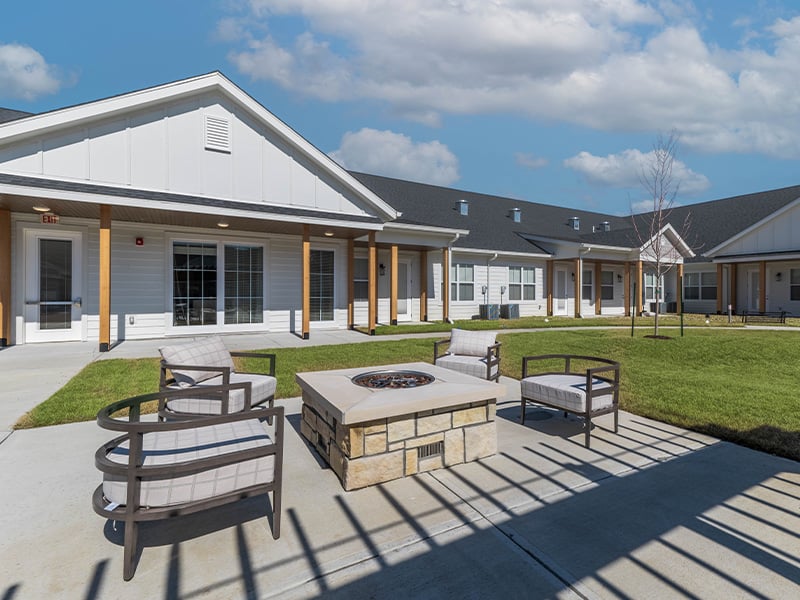 An inviting outdoor patio space with fireplace at Cedarhurst of Topeka senior living community