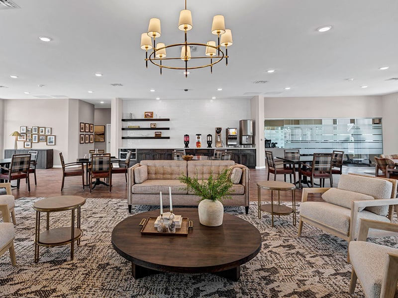 Clubhouse interior with lounge seating and dining tables at Cedarhurst of Topeka's Independent Living at Cedarhurst Cottages