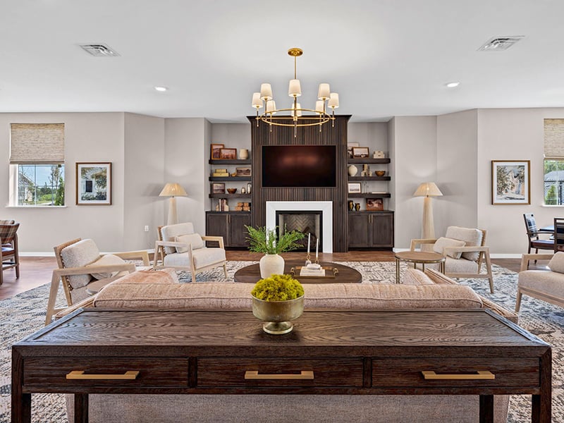 Clubhouse lounge with a fireplace and built-in shelving at Cedarhurst of Topeka's Independent Living at Cedarhurst Cottages