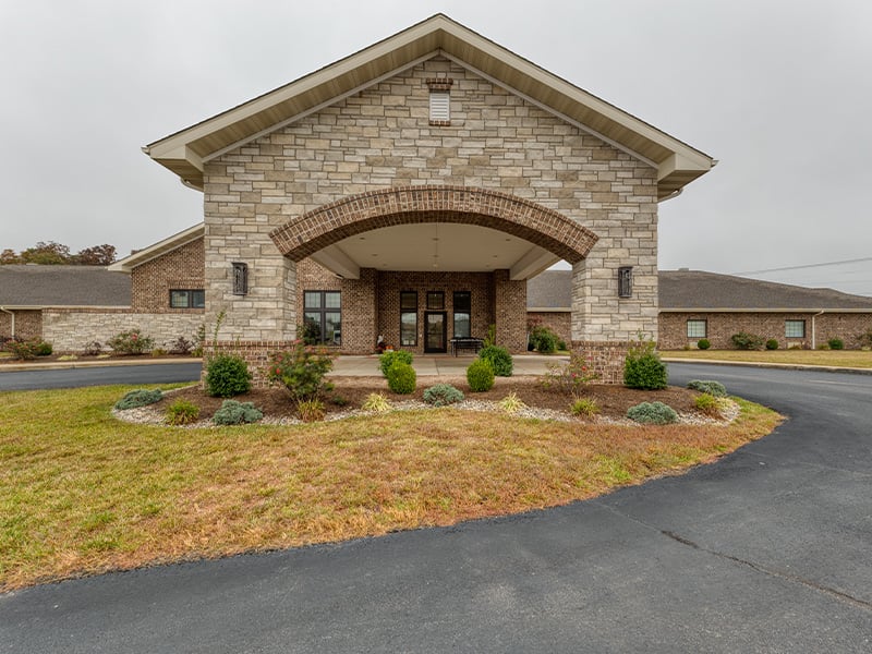 An inviting view of the Cedarhurst of Waterloo senior living community from the outside, complete with the main building and its distinctive sign