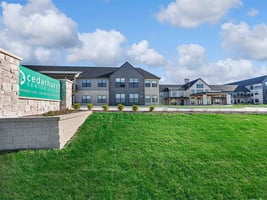 The welcoming exterior of Cedarhurst of Wentzville senior living community, with its prominent sign visible