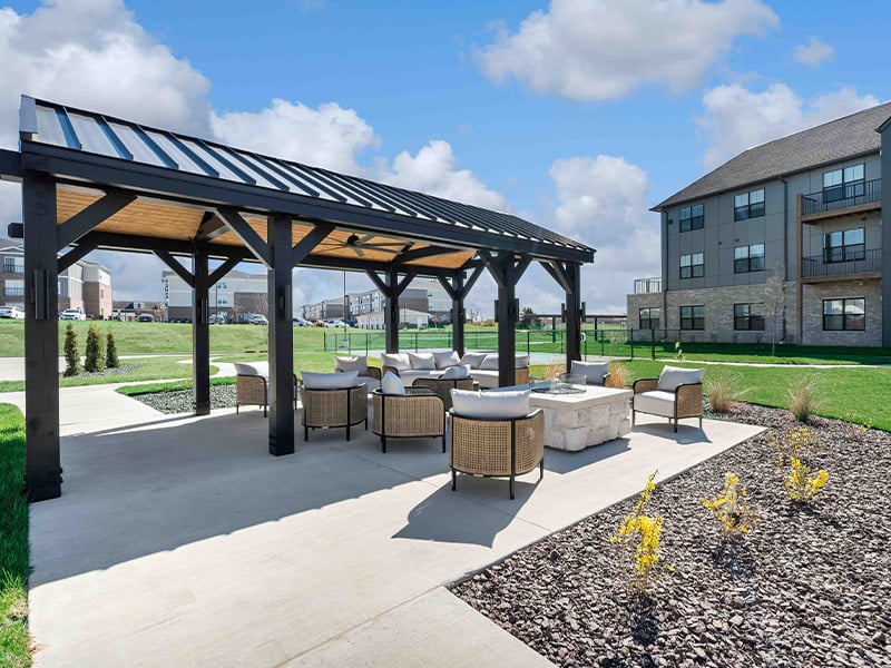 An inviting outdoor patio space with a wooden pergola at Cedarhurst of Wentzville senior living community