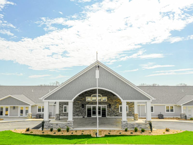 An inviting view of the Cedarhurst of West Plains senior living community from the outside, complete with the main building and its distinctive sign.