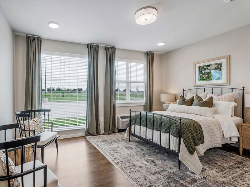 Cedarhurst of Wichita: A cozy and well-appointed senior apartment bedroom for residents
