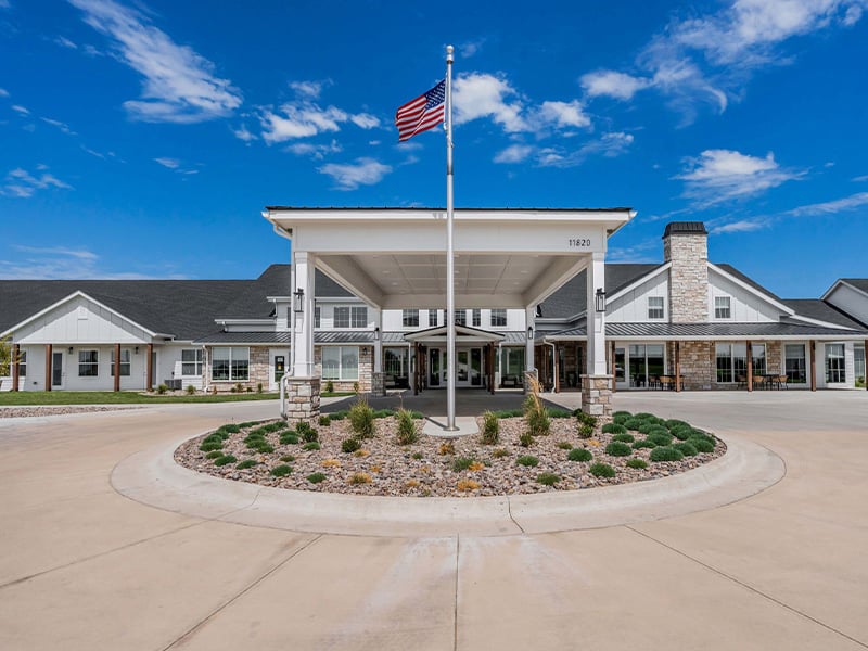 An inviting view of the Cedarhurst of Wichita senior living community from the outside, complete with the main building and its distinctive sign
