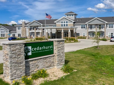 An inviting view of the Cedarhurst of Yorkville senior living community from the outside, complete with the main building and its distinctive sign