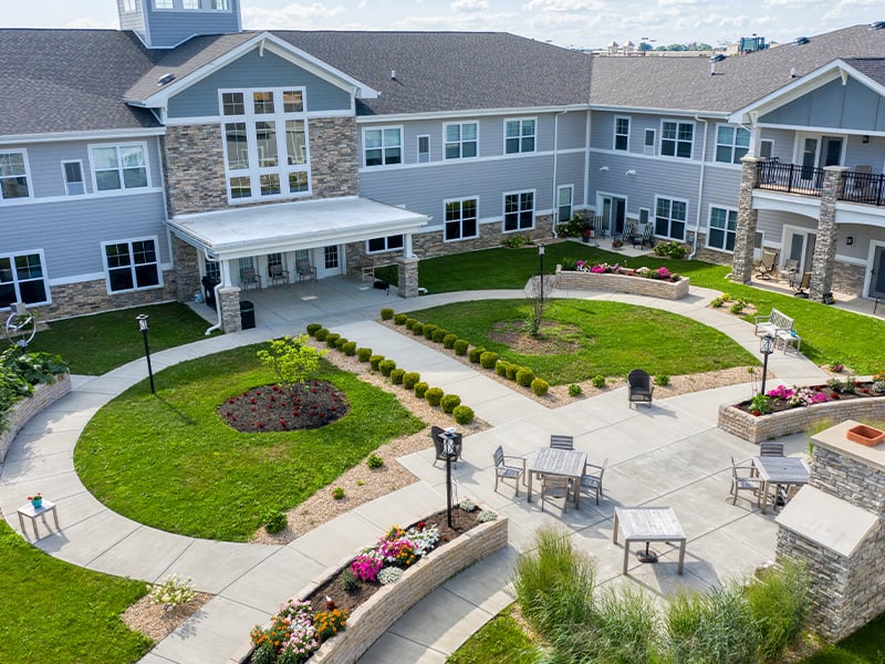 Aerial view of outdoor green space at Cedarhurst of Yorkville with paved walking paths and comfortable seating