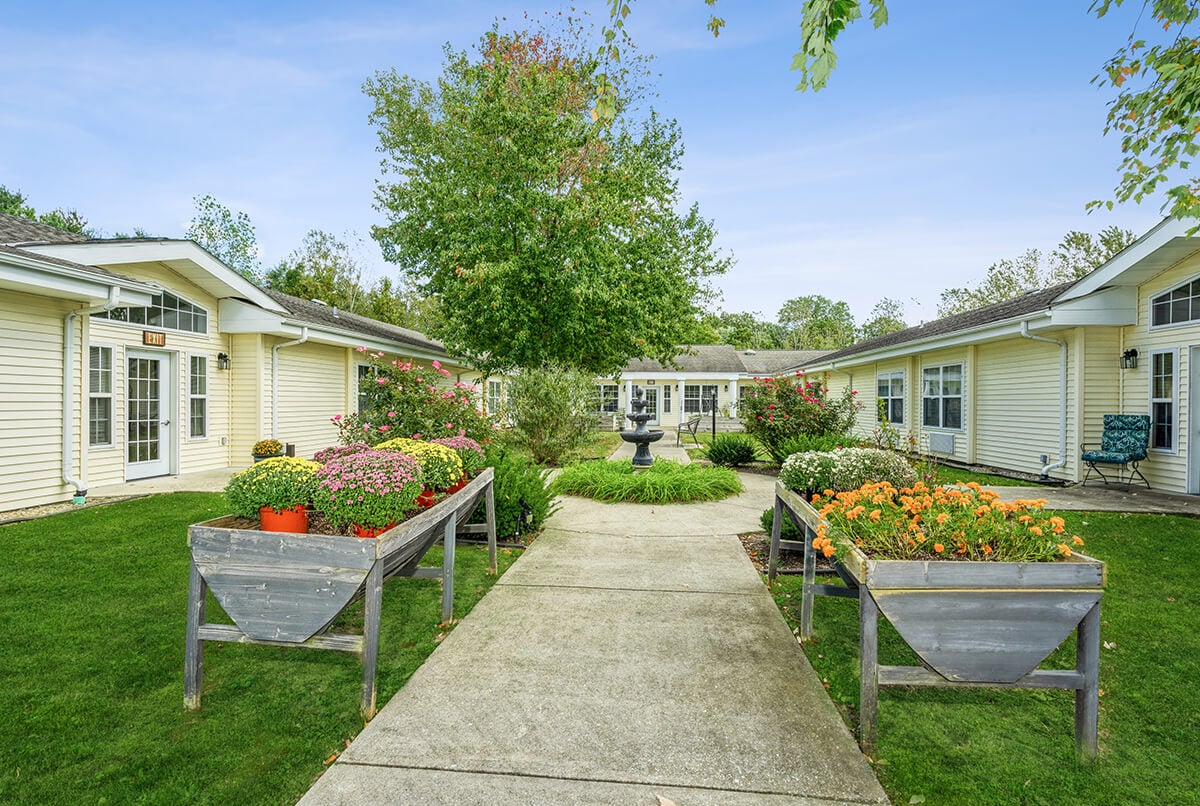 The courtyard of Cedar Creek Bedford, filled with raised planting beds and a fountain