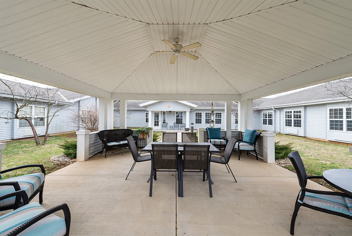 The Courtyard at Cedar Creek of Bloomington, a covered green area full of plush lounge furniture