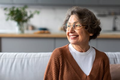 senior woman sitting on couch while smiling