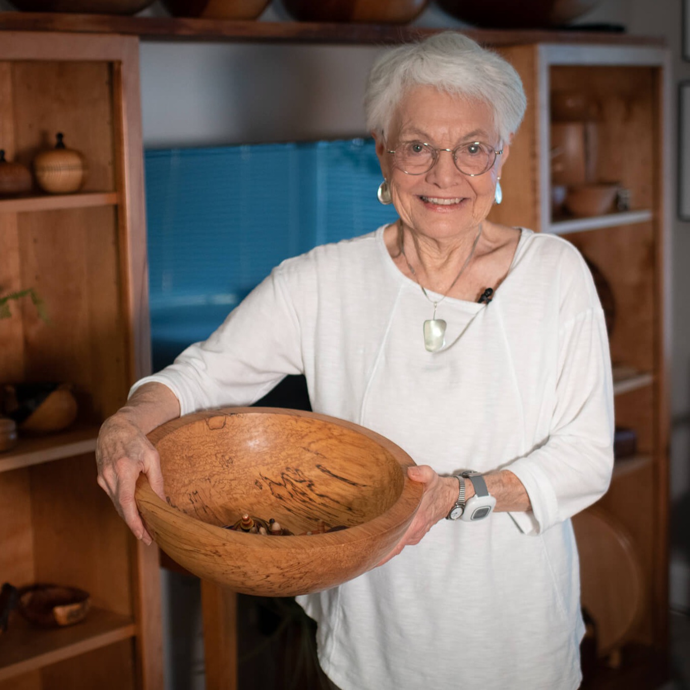 Shirley, a resident, holding a wooden bowl