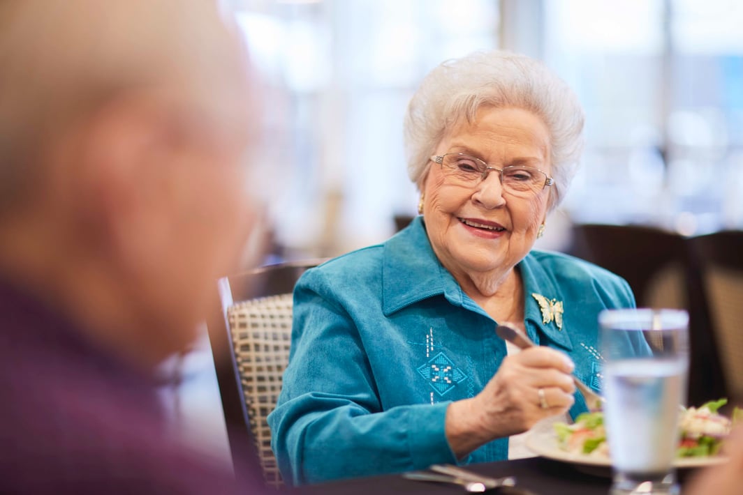 A senior woman eating lunch with friends