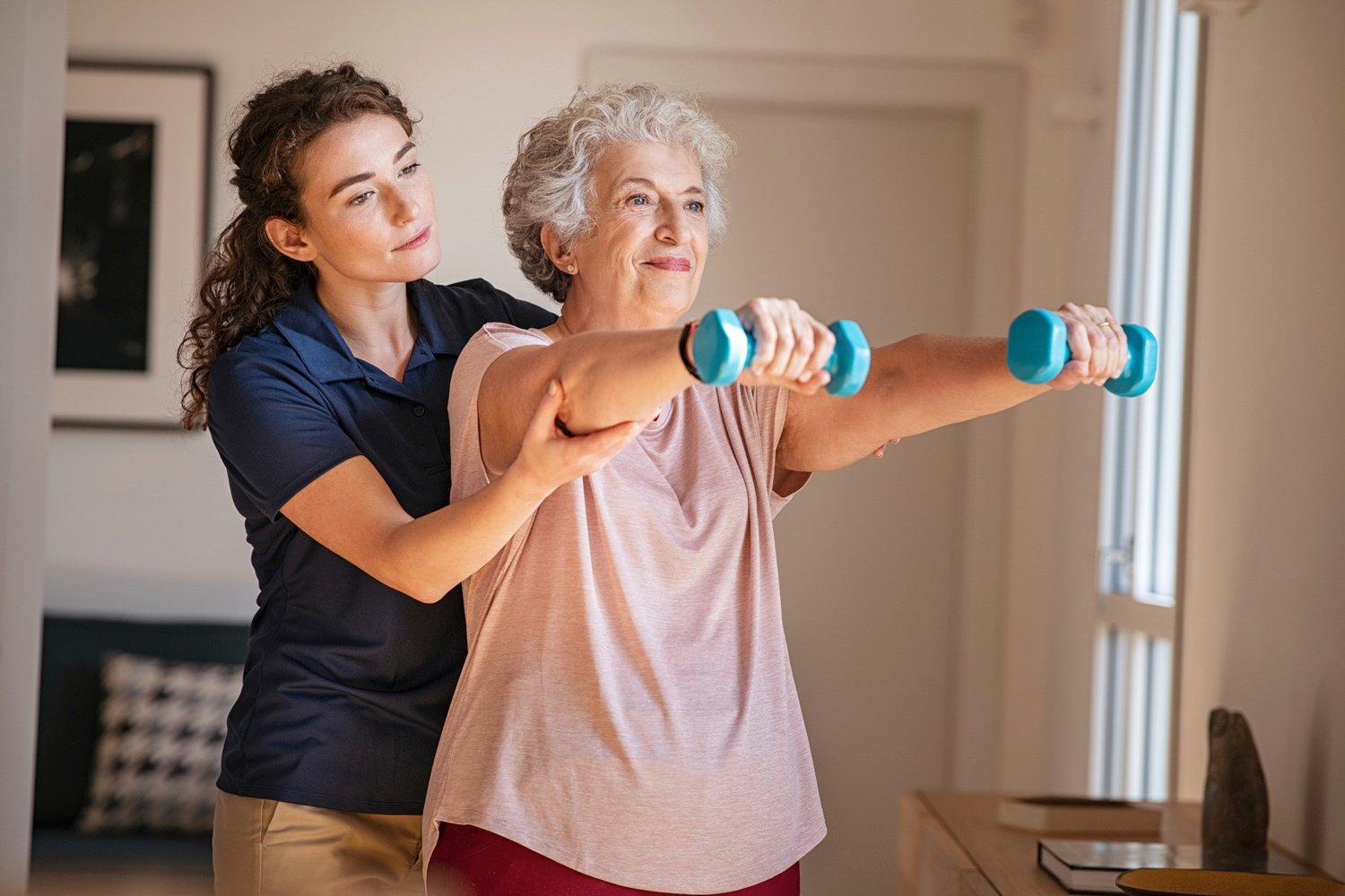senior woman and caregiver exercising