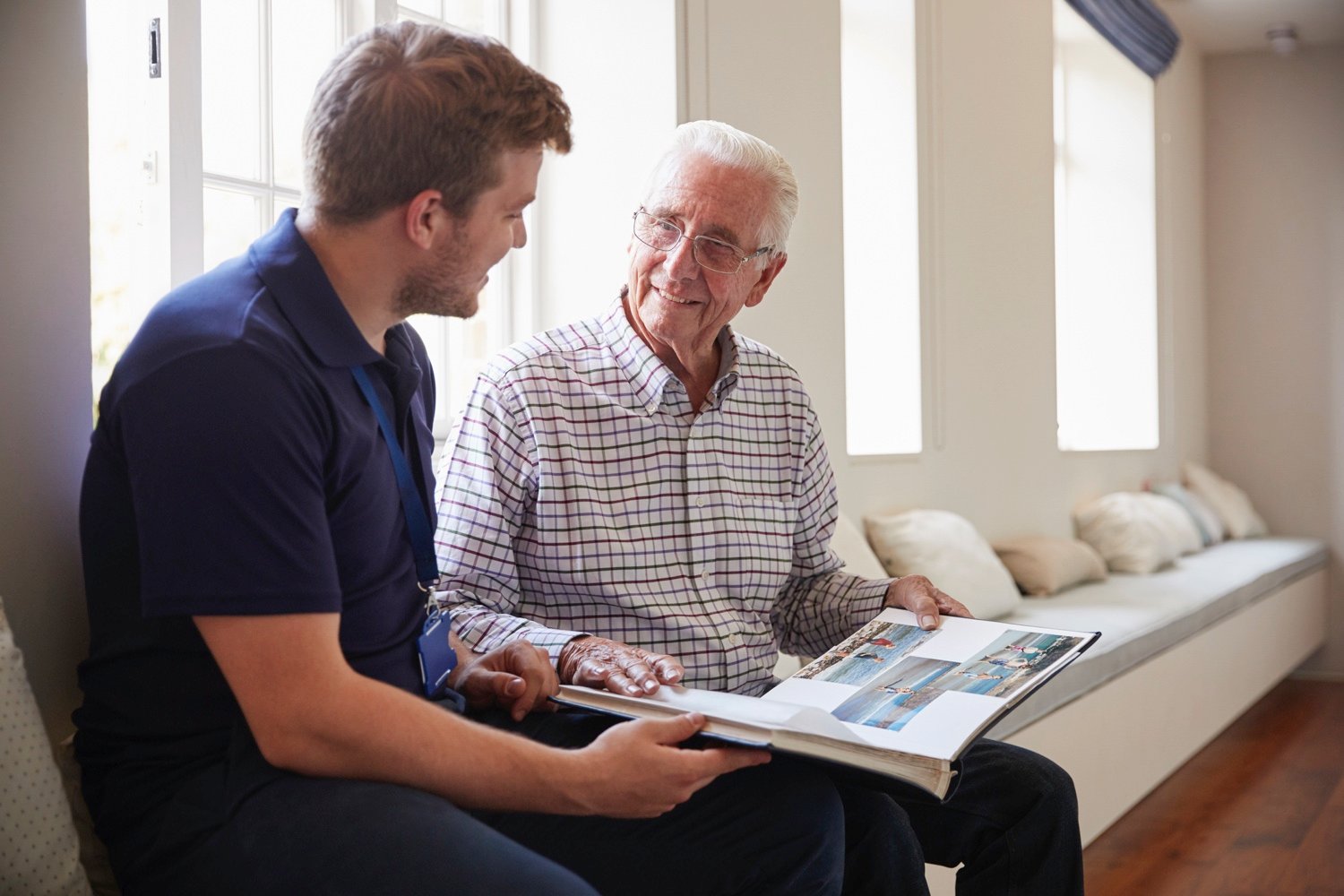 senior man reading with younger man