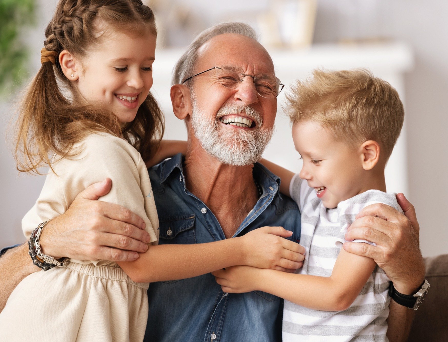 Grandfather hugging grandchildren