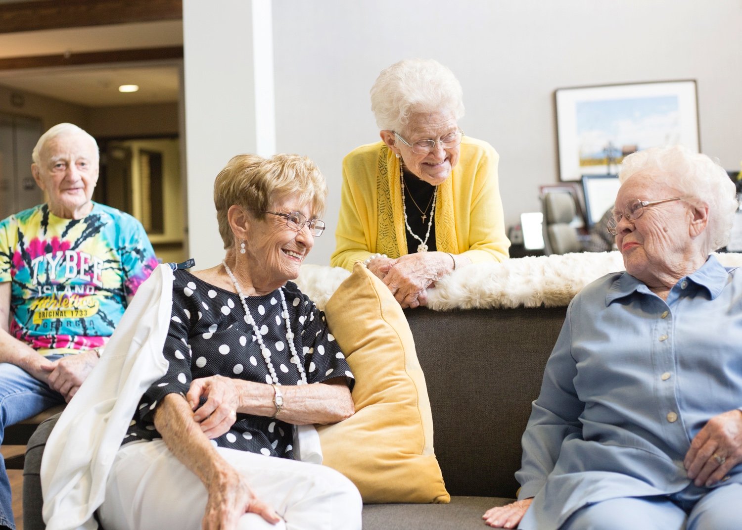 Group of seniors laughing on couch