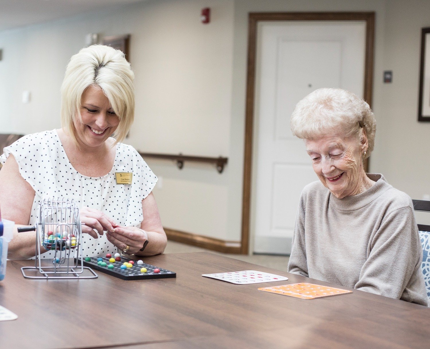 A staff member playing a game with a resident at a table