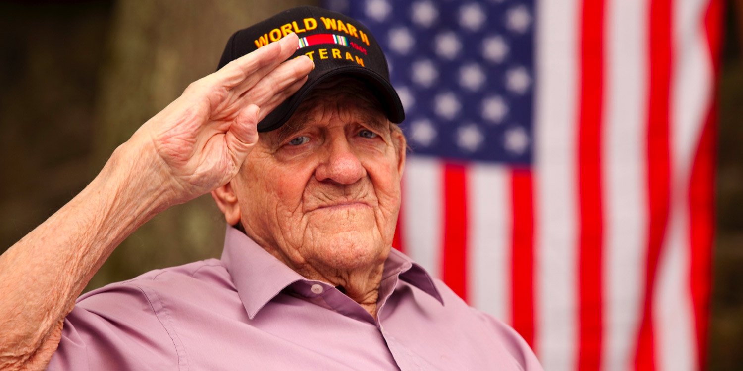 World War veteran standing in front of American flag while saluting