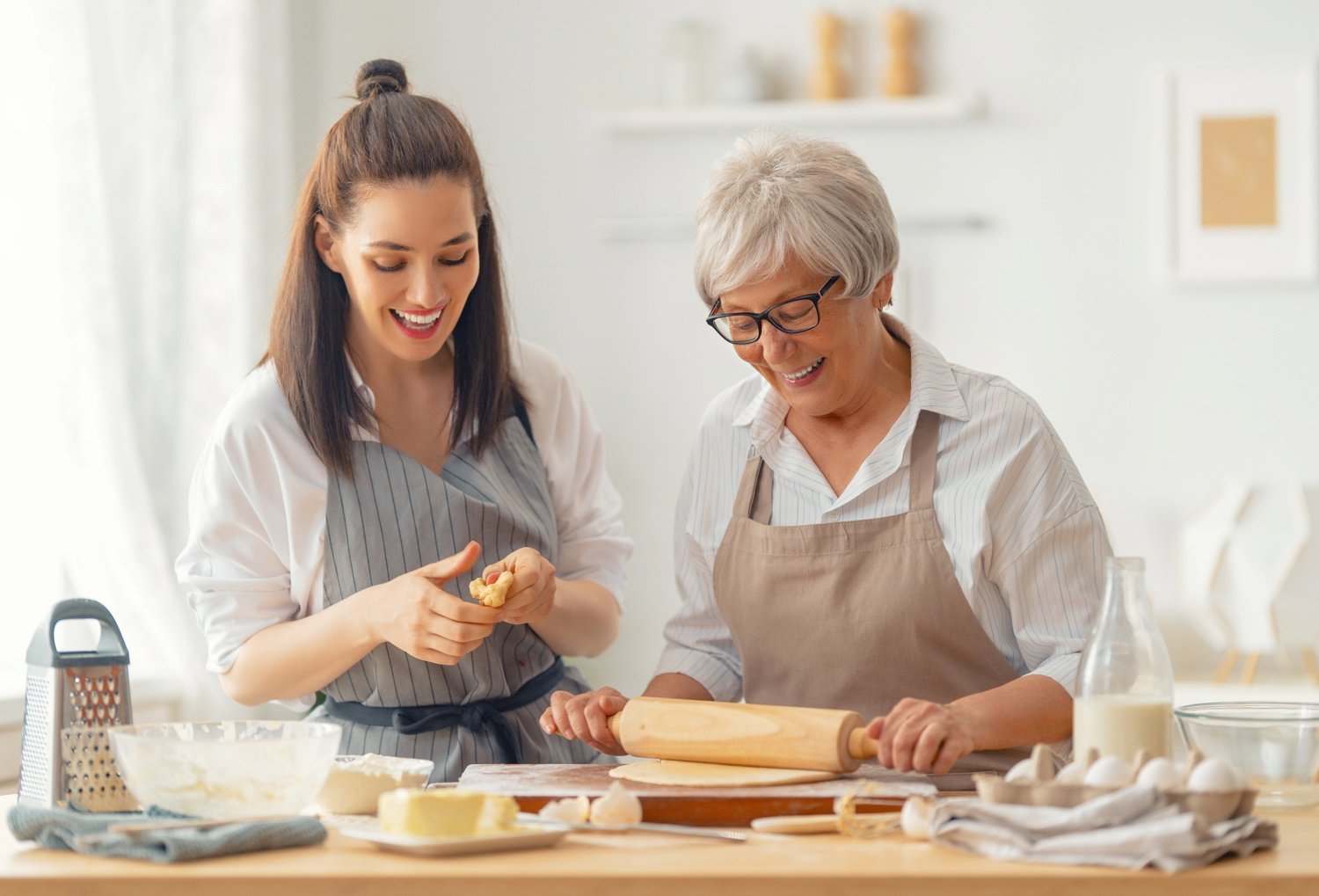 A senior woman and younger woman baking together
