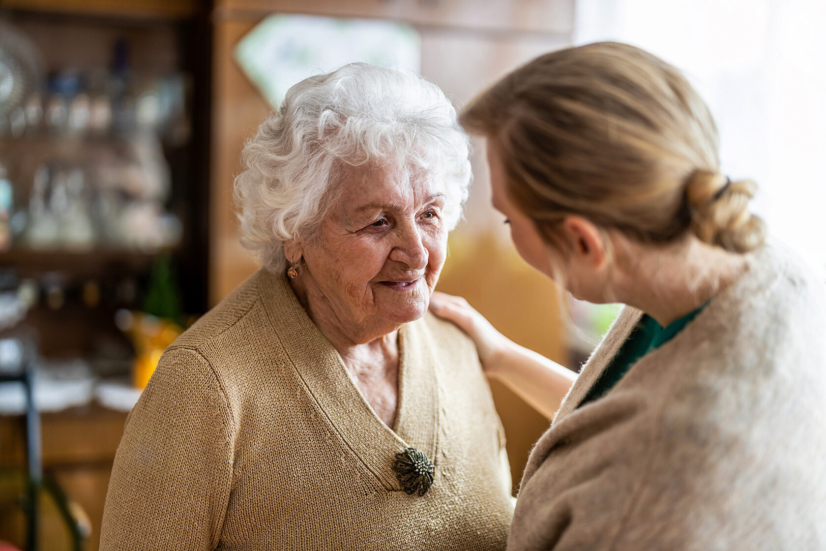 Senior caregiver talking to memory care resident