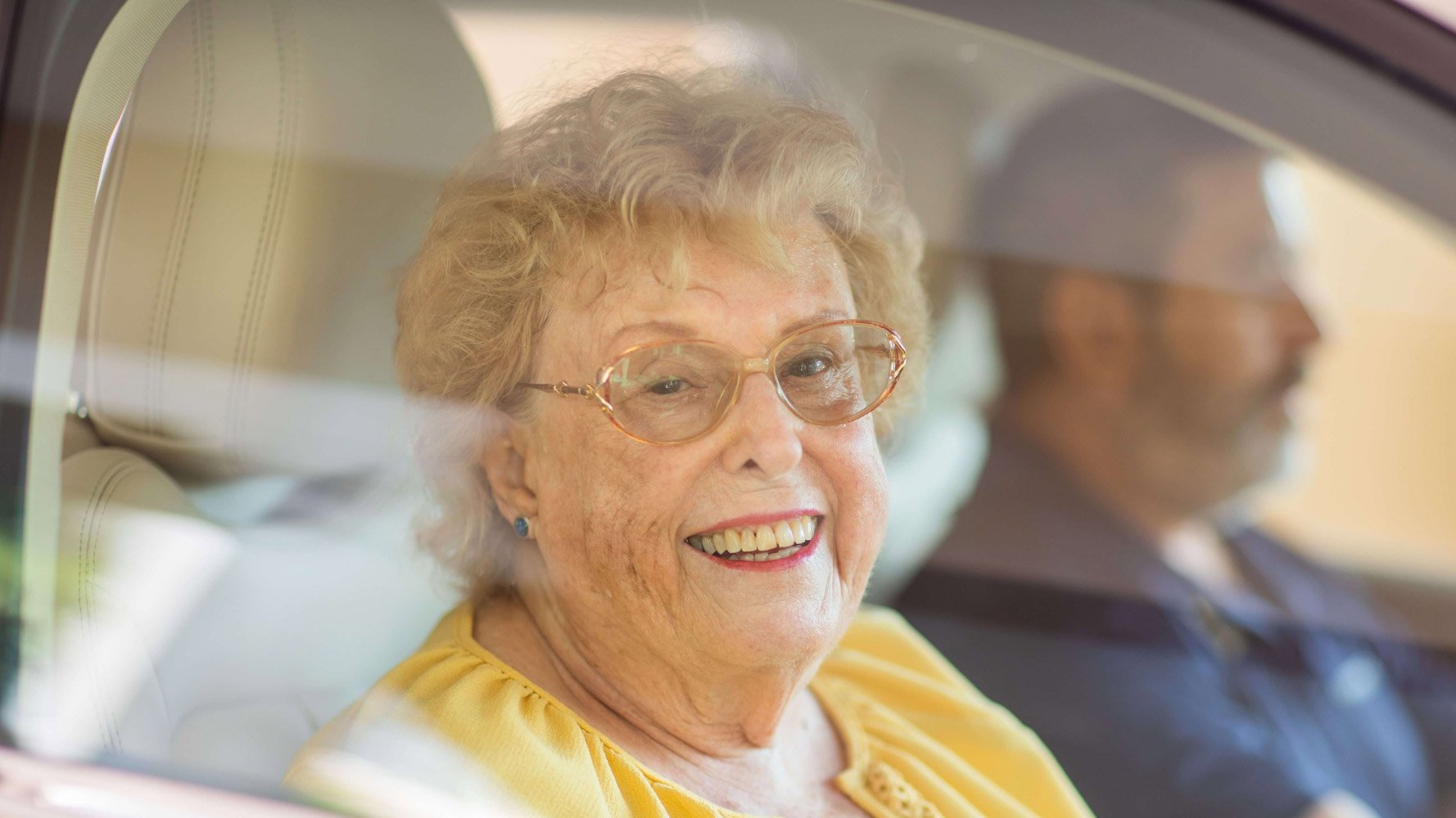 Senior woman sitting in passenger seat of a car