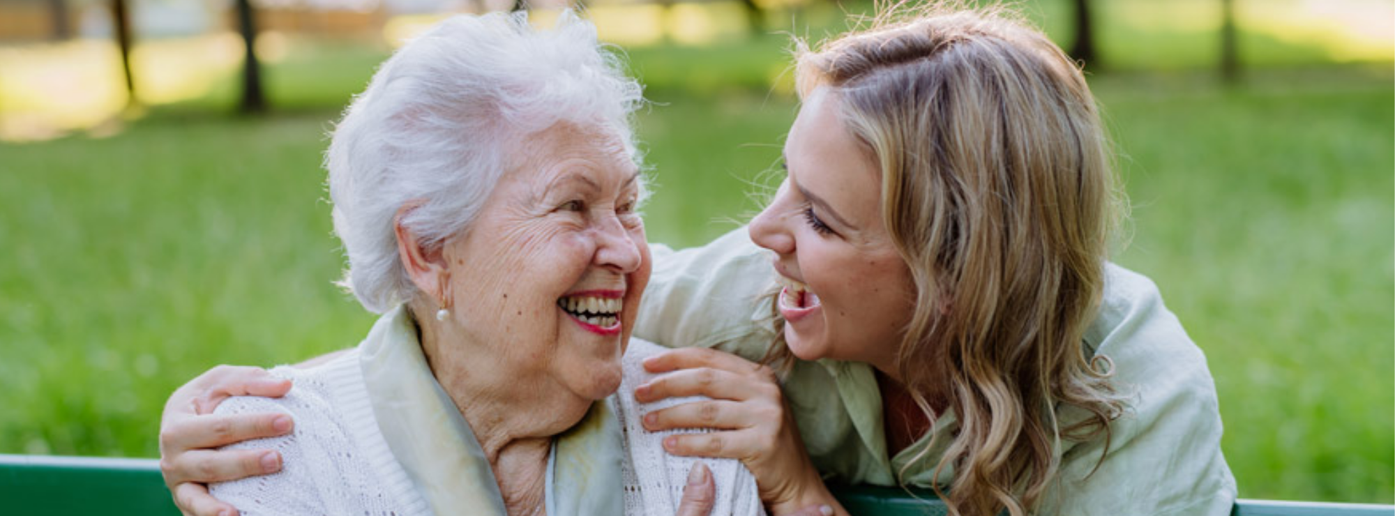 adult daughter smiling at senior grandmother -