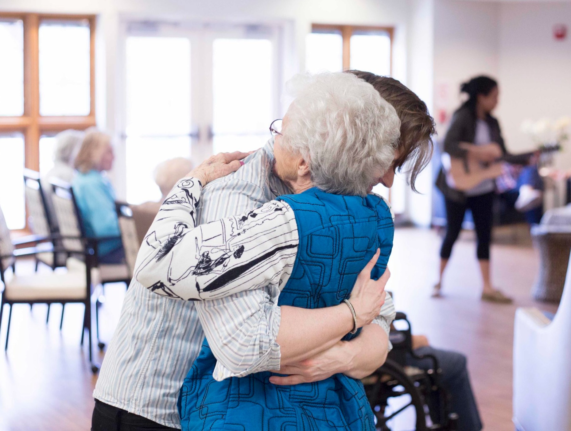 Staff member hugging a senior woman