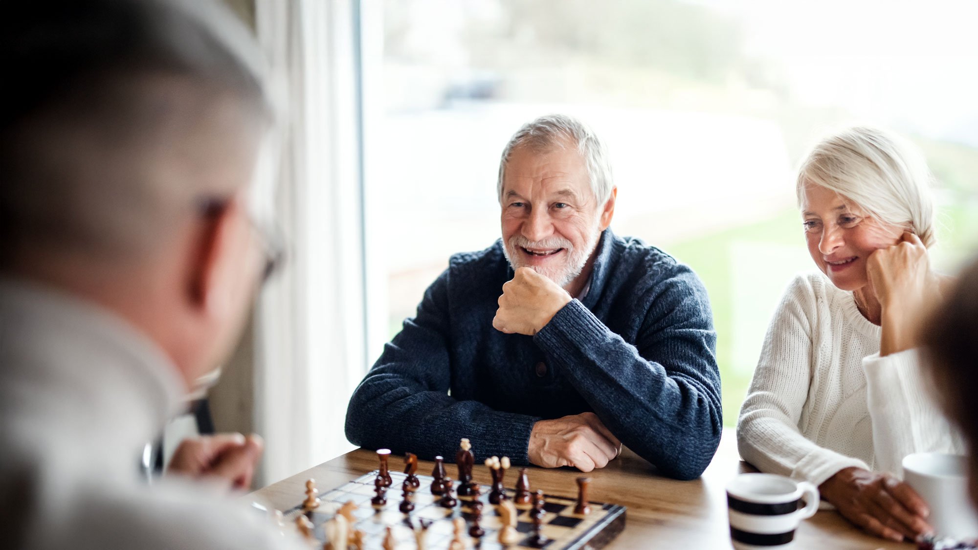 senior friends playing chess together