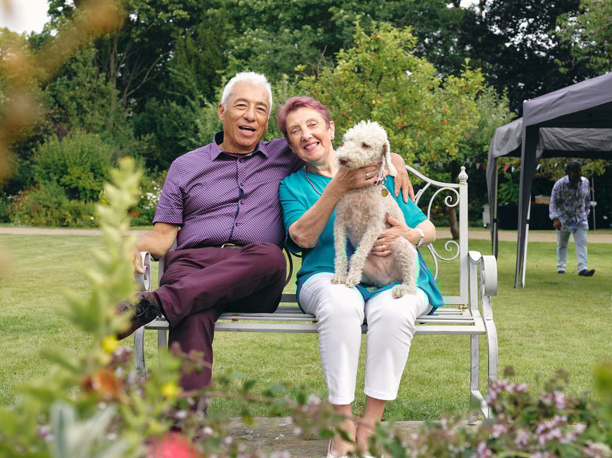Senior sitting outside with small dog in lab