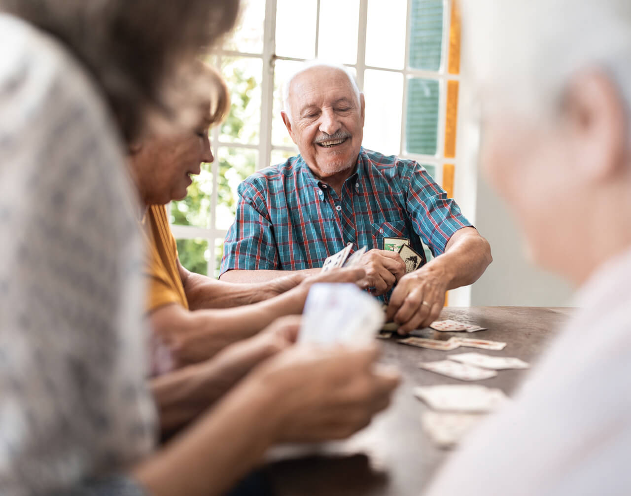Group of seniors playing cards at senior living community