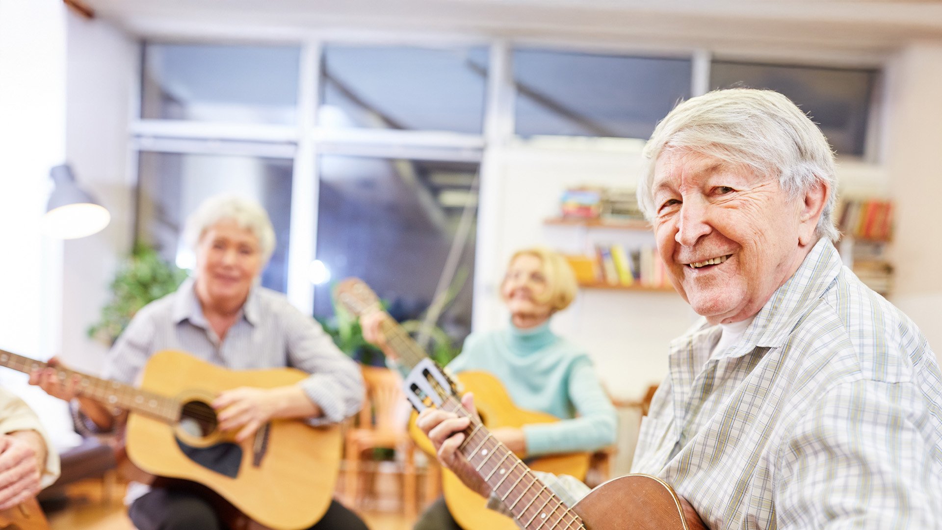 Senior living resident holding a guitar