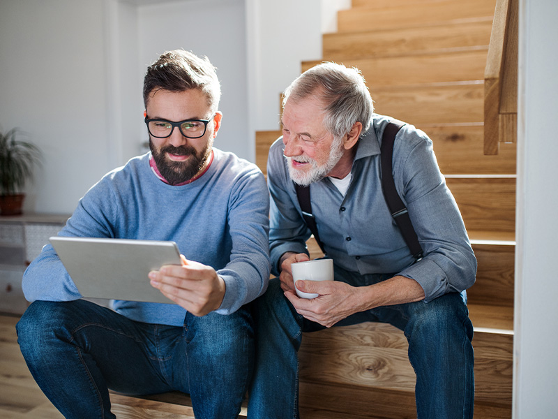 Elderly man looking for information with his son