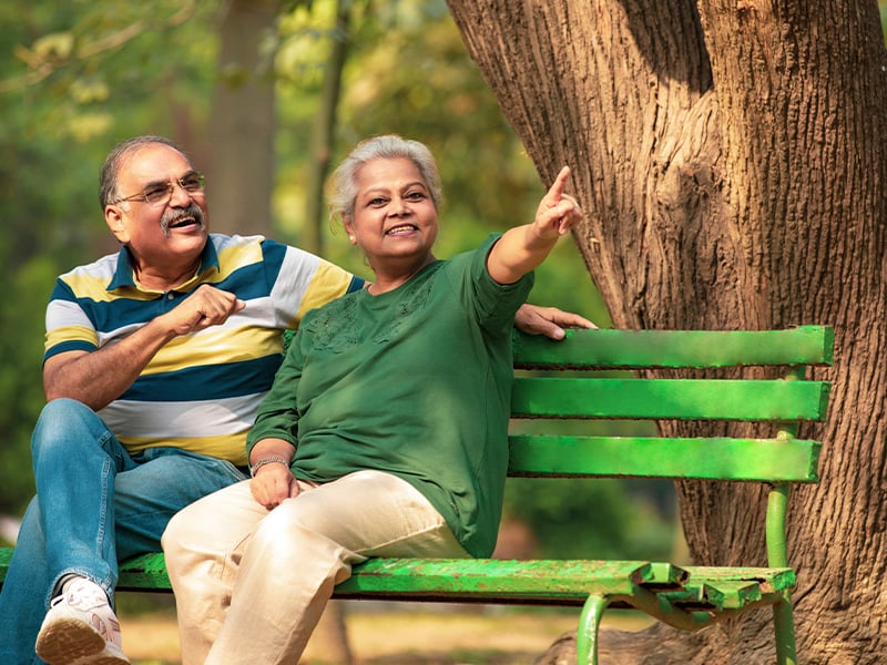 Senior living residents sitting outside on a bench