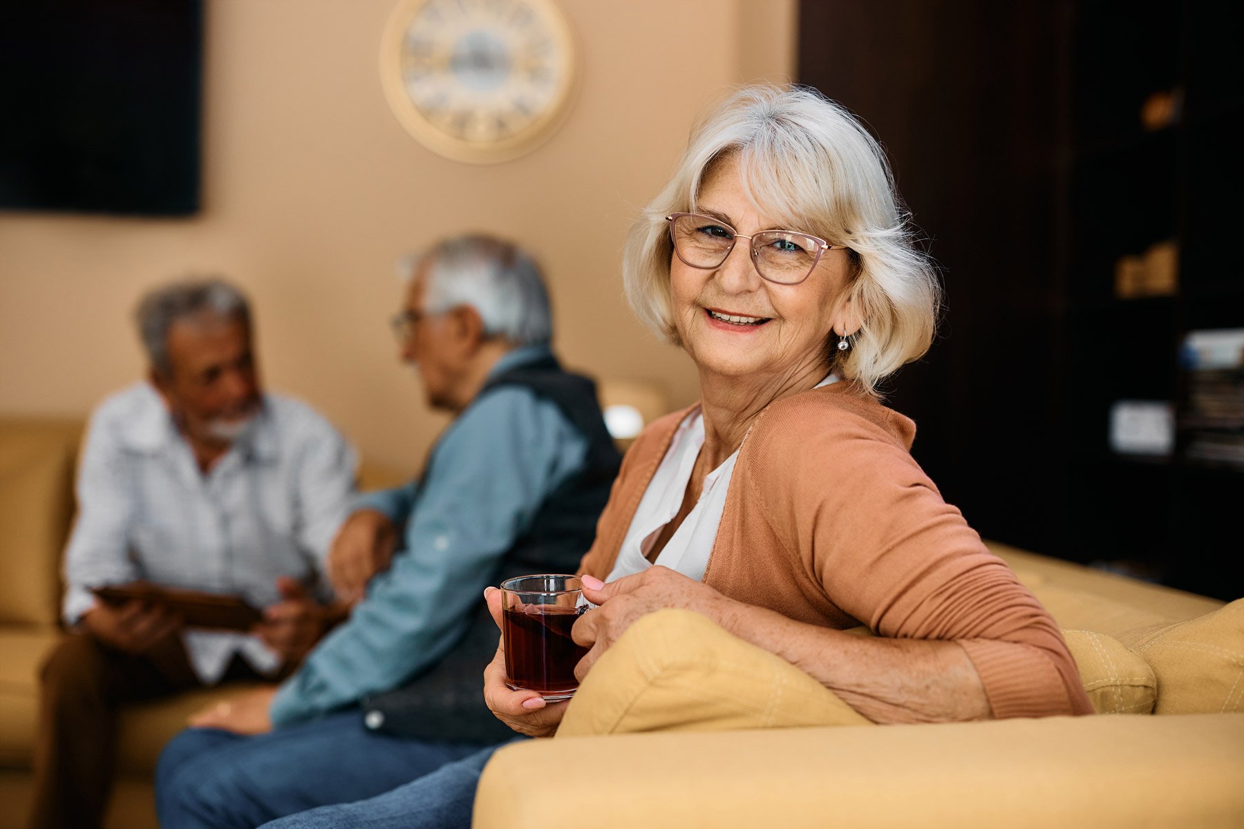 senior woman sitting on couch with cup of coffee