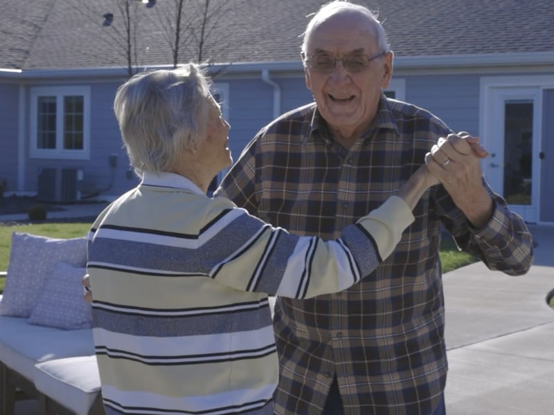 Still from a video of a senior couple dancing outside