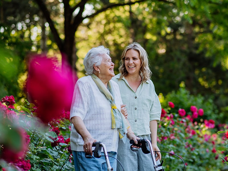 Senior woman walking around with staff member