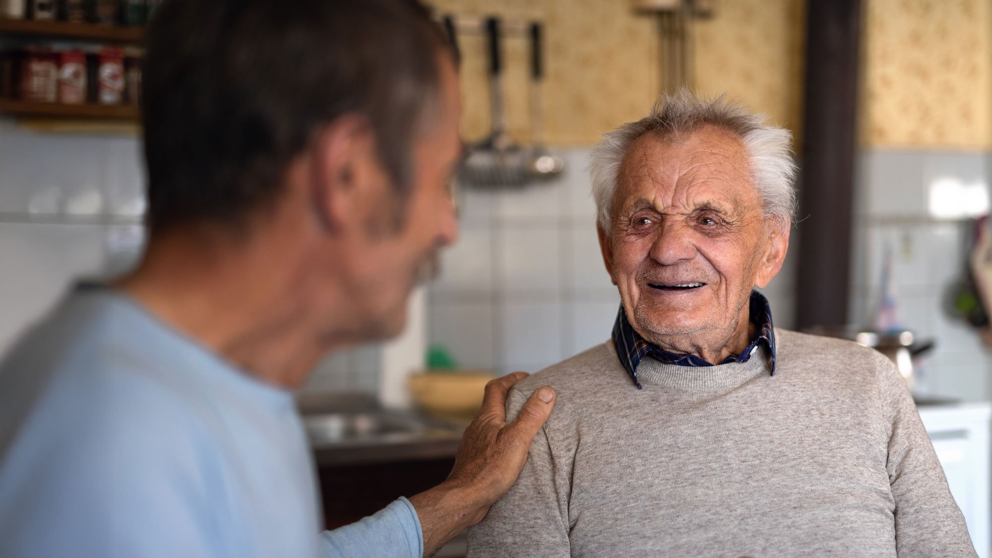 senior man sitting in kitchen
