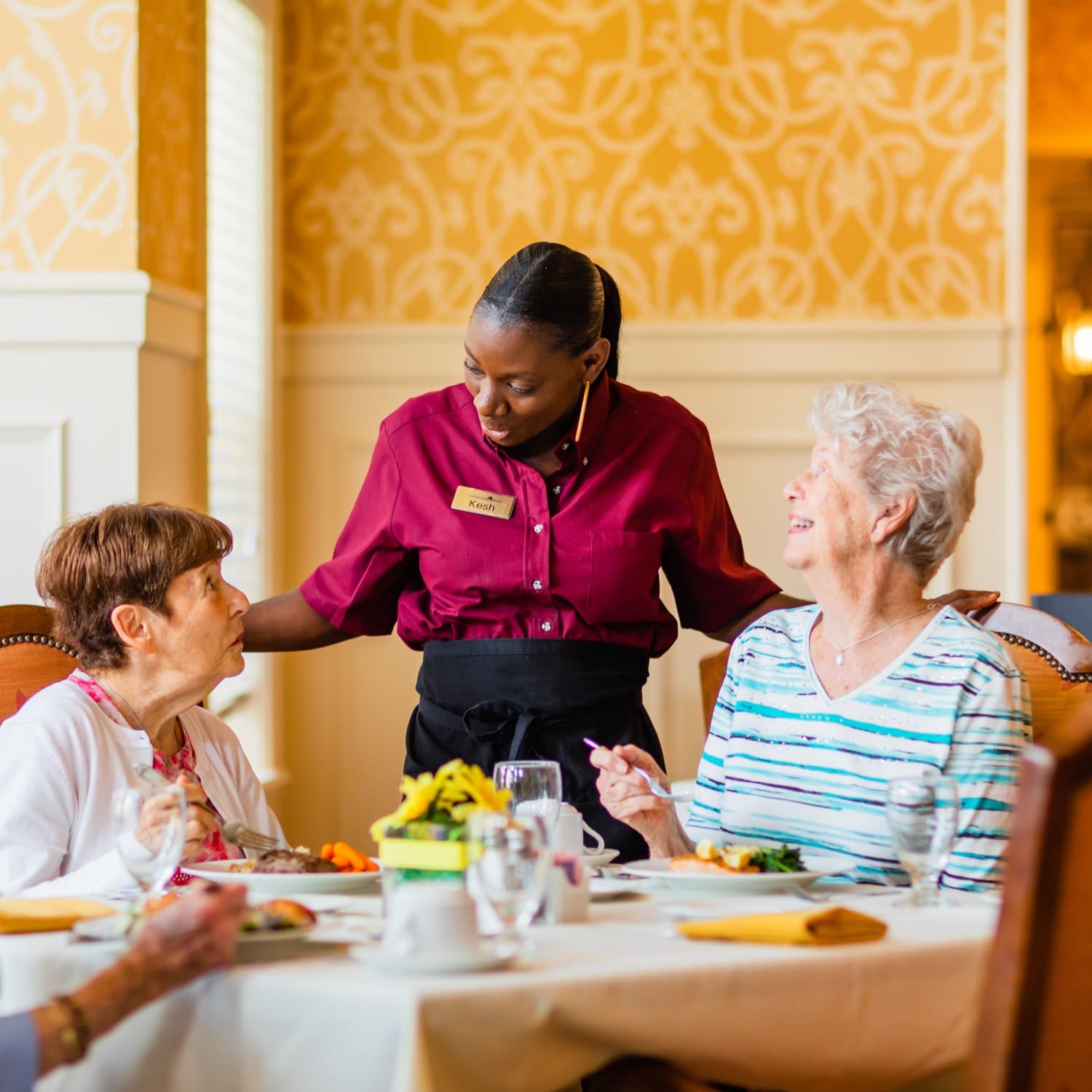 senior women smiling with waitress