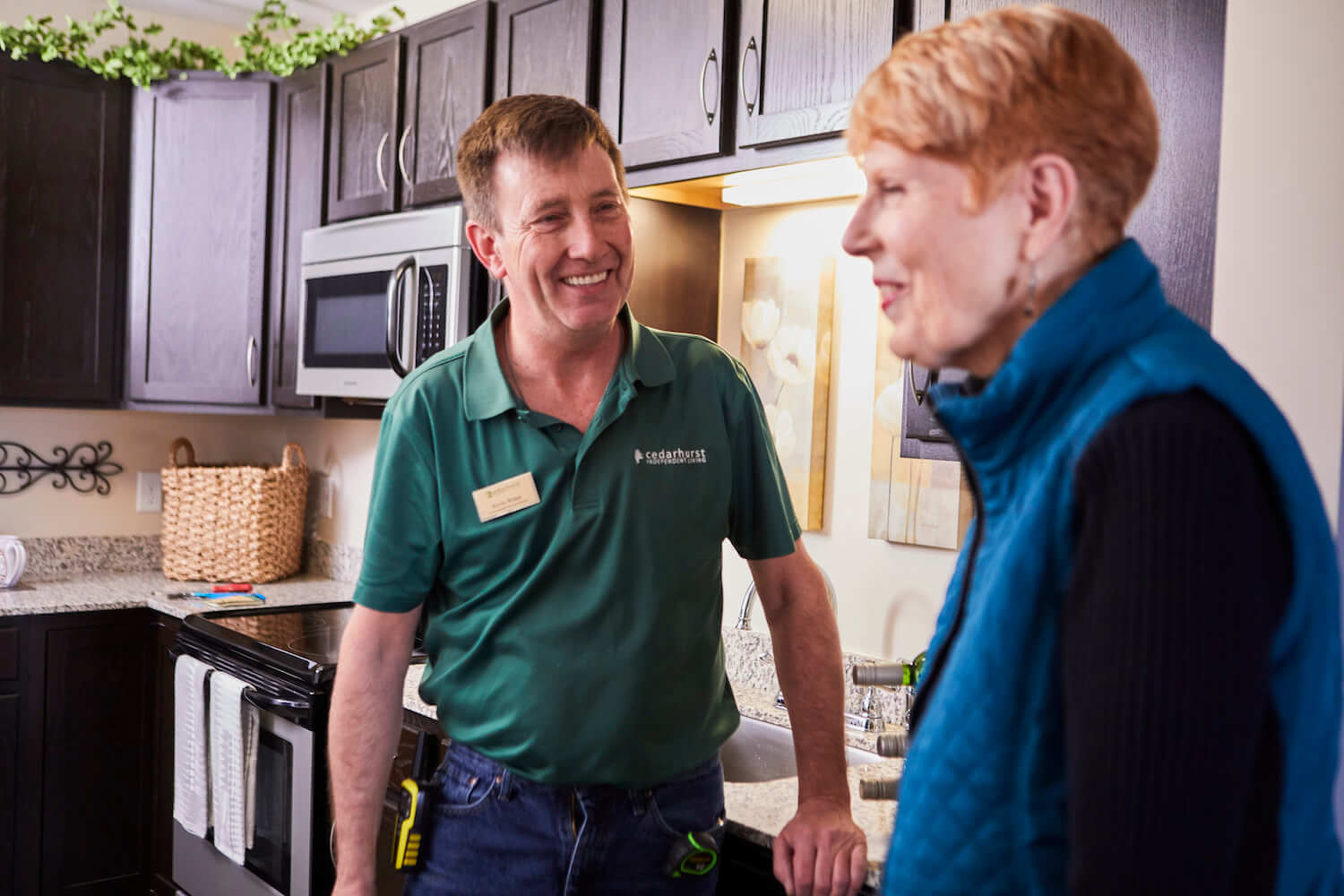 A team member chatting in a kitchen with a resident