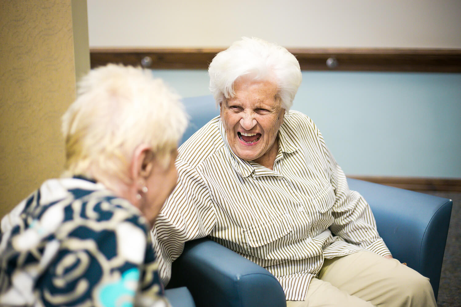 Two seated senior women laughing together 