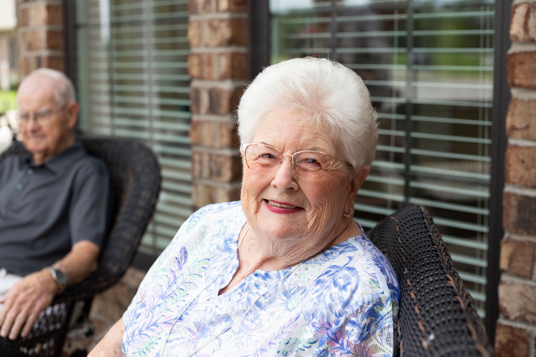 Senior woman smiling at the camera as she socializes with friends on a patio