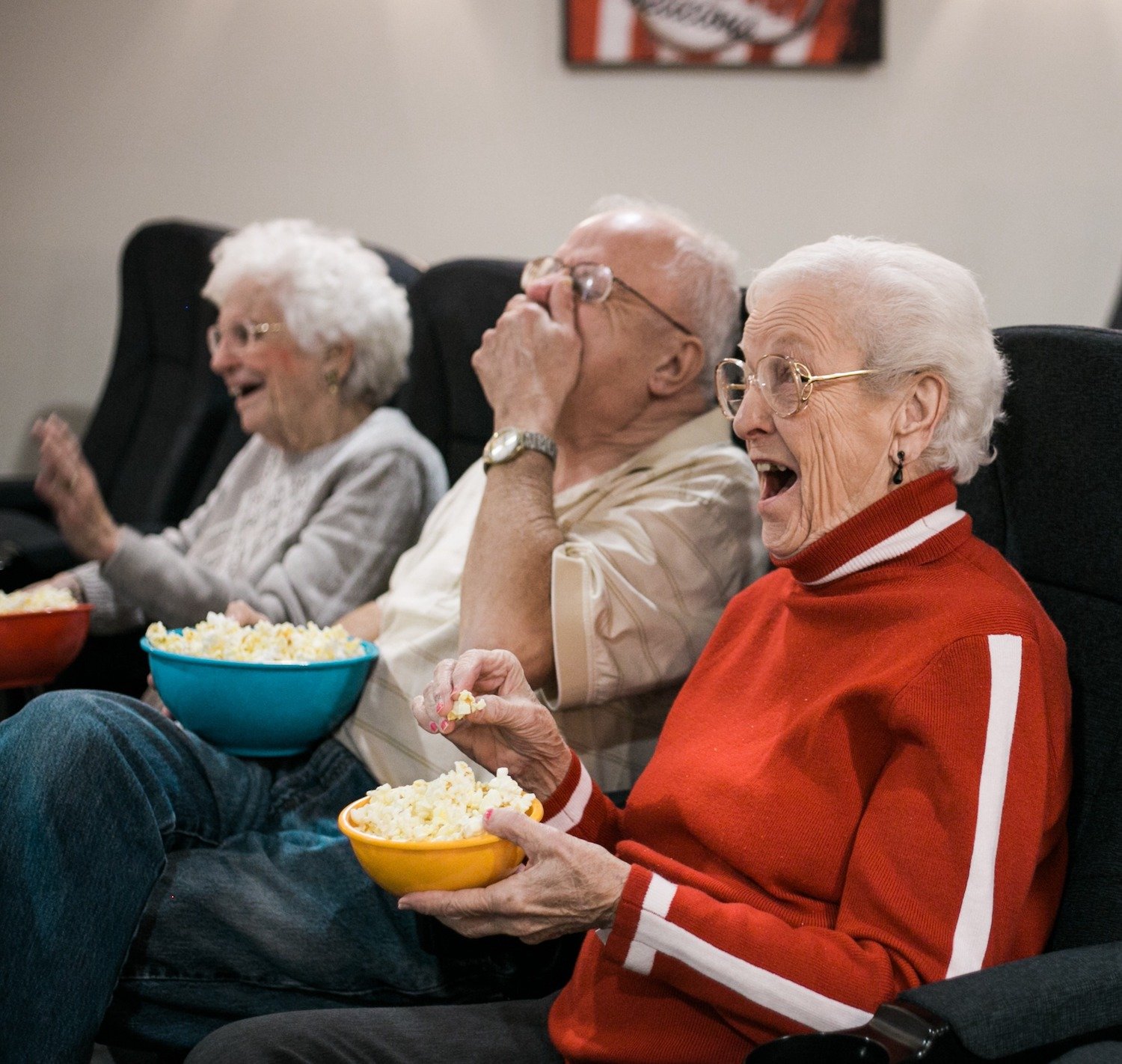 Group of seniors watching a movie and eating popcorn