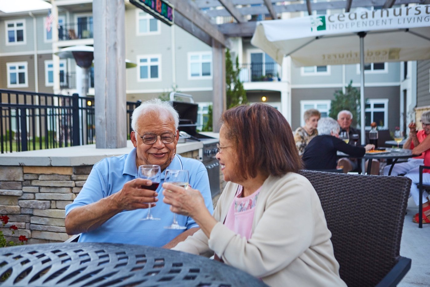 A couple toasting with drinks on the patio