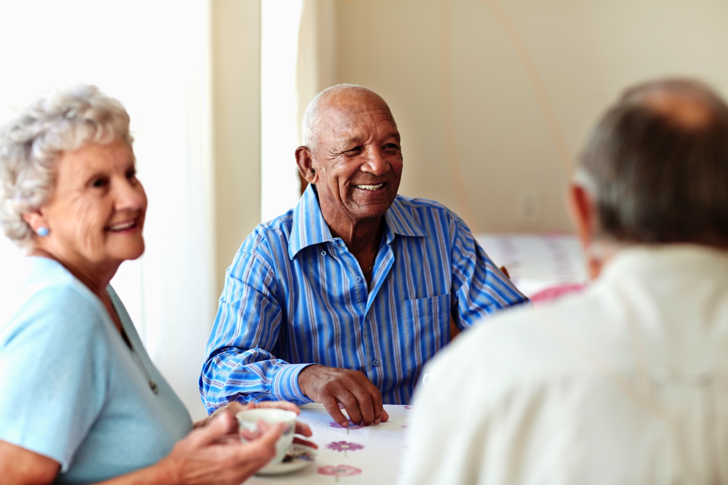 Senior friends enjoying tea at a kitchen table