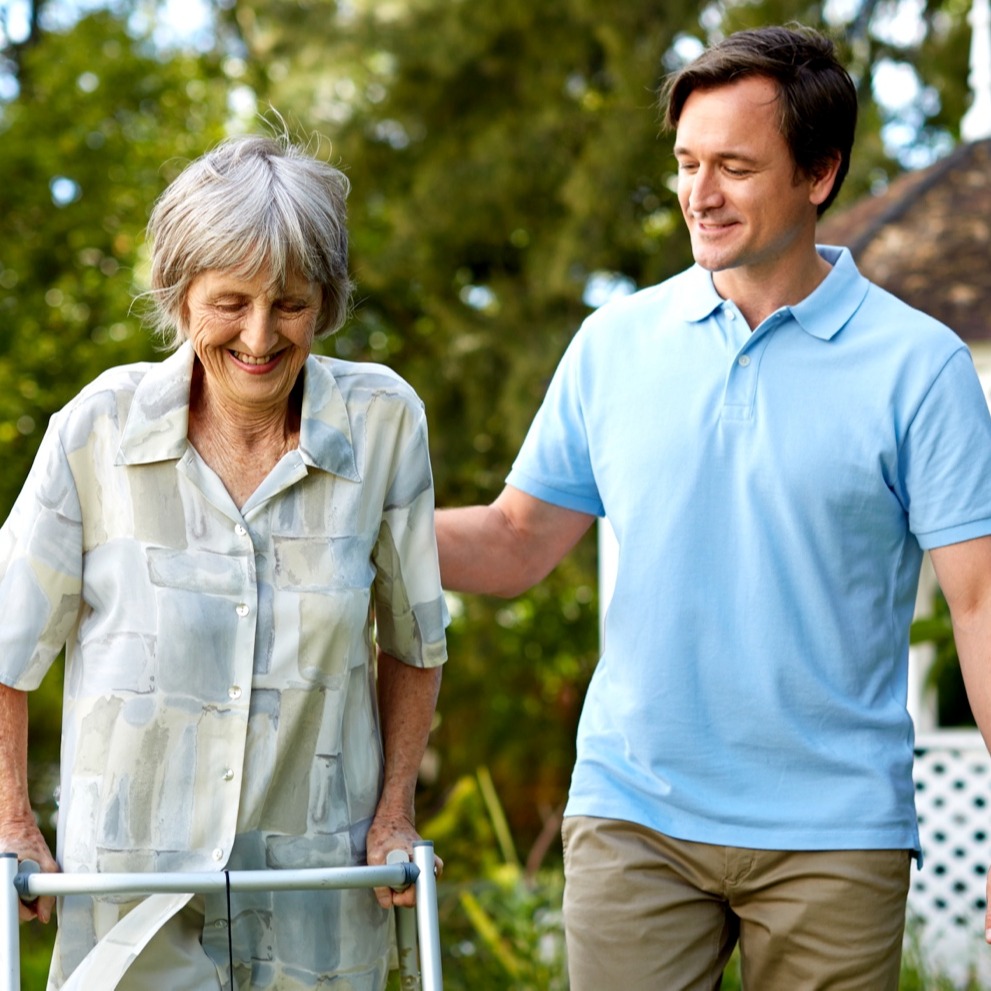 Carer helping senior with walker in garden-1-1-1