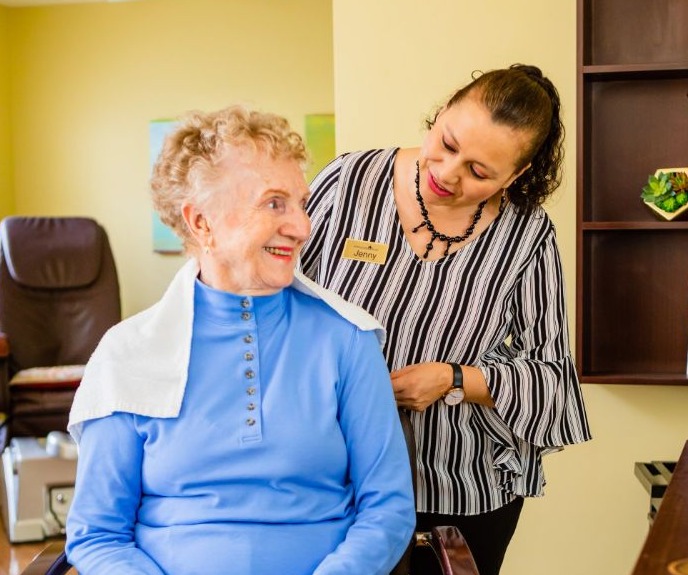 A stylist cutting a senior woman's hair in the community salon