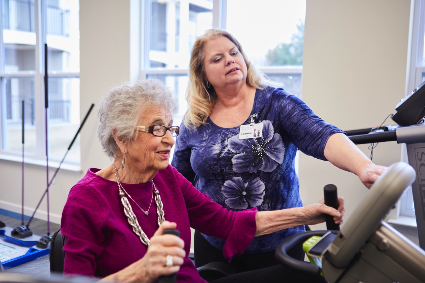 Staff member helping senior woman with physical therapy